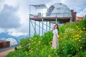 een vrouw in een bloemenveld bij เดอะโดมโฮมสเตย์ ม่อนแจ่ม in Mon Jam