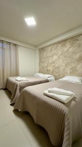 a room with three beds with towels on them at Castellares la Puebla Hostelería Departamento in Ayacucho