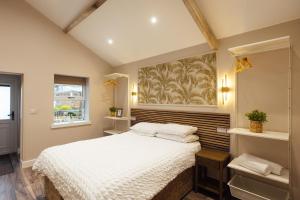a bedroom with a white bed and a window at The Dolphin Hotel & Restaurant in Pembroke Dock