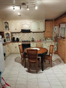 Maison Appartement plein Centre Saint Astier في Saint-Astier: مطبخ يحتوي على طاولة وكراسي خشبية +6 صور