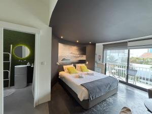 een slaapkamer met een groot bed en een balkon bij LUZZ me - Casa de Angra in Angra do Heroísmo