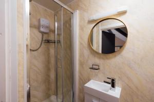 a bathroom with a shower and a sink and a mirror at The Dolphin Hotel & Restaurant in Pembroke Dock +80 photos