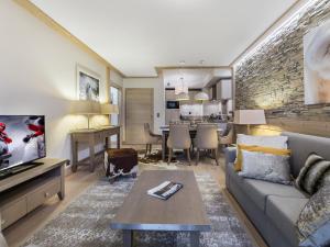 ein Wohnzimmer mit Sofa und Tisch in der Unterkunft Appartement 3P au coeur de Courchevel, proche commerces et pistes, parking inclus - FR-1-562-10 in Courchevel