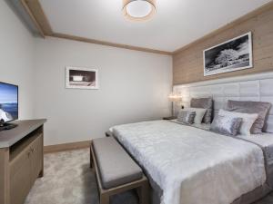 ein Schlafzimmer mit einem großen Bett und einem Schreibtisch in der Unterkunft Appartement 3P au coeur de Courchevel, proche commerces et pistes, parking inclus - FR-1-562-10 in Courchevel