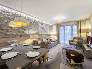 ein Esszimmer und ein Wohnzimmer mit Tisch und Stühlen in der Unterkunft Appartement 3P au coeur de Courchevel, proche commerces et pistes, parking inclus - FR-1-562-10 in Courchevel