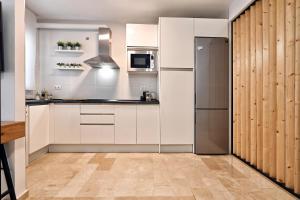 kuchnia z białymi szafkami i lodówką ze stali nierdzewnej w obiekcie Love Rent4 Málaga Rafa w Maladze +7 zdjęć