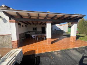 a pavilion with a table on a brick patio at Villa Antaquira in Antequera