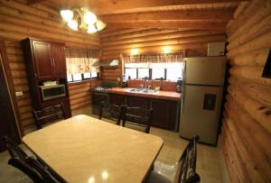 a kitchen with a table and a refrigerator at Cabaña El Vado de Ciénega 1 in Ciénaga