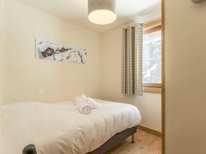 a small bedroom with a bed and a window at Magnifique 6 pièces aux Arcs 1600, PISCINE, SPA, pied de pistes, pour 12 pers. - FR-1-461A-6 in Arc 1600