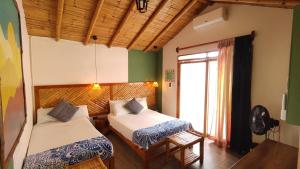 a bedroom with two beds and a window at Puerto Bamboo in Máncora