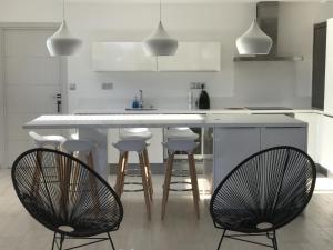 una cocina con encimera blanca y taburetes de bar en Sweet Holiday, en Porto Vecchio