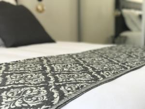 una manta blanca y negra en una cama en Sweet Holiday, en Porto Vecchio