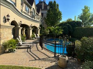 a house with a fence and a swimming pool at Le St-Martin Hotel & Suites in Laval