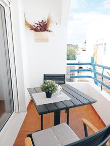 a small balcony with a black table and chairs at Apto Mediterraneo WIFI GRATIS in San José