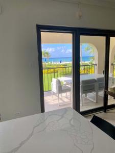 a dining room with a view of the ocean at Oceanfront Condo on Seven Mile Beach in Dog City +22 photos