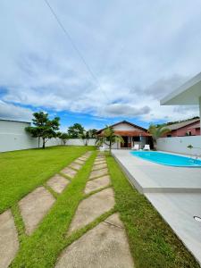 einen Hinterhof mit Pool und Gras in der Unterkunft Seu espaço em floripa! in Florianópolis