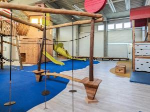 einen Fitnessraum mit einem Spielplatz mit Rutsche und Schaukeln in der Unterkunft 6 Personen Ferienhaus in Wendtorf in Wendtorf