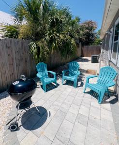 巴拿马城海滩Beach Haven的庭院里设有三把椅子和烤架