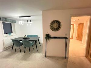 a dining room with a table and chairs and a clock at 8 Ashton Villa in Broadstairs