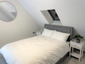 a bedroom with a white bed and a mirror at 8 Ashton Villa in Broadstairs