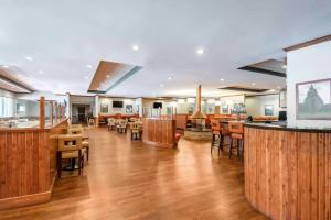 ein Restaurant mit Holzböden und Holztischen und -stühlen in der Unterkunft Holiday Inn Frisco by IHG in Frisco