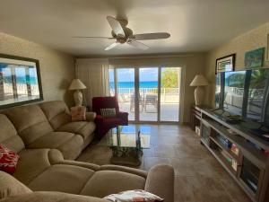 a living room with a couch and a flat screen tv at Oceanfront 3-BR Condo with Large Beachfront Terrace in Dog City