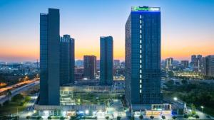 a city skyline with two tall skyscrapers at dusk at Holiday Inn Express Guangzhou University Town - Shuttle Service During Canton Fair - Free Morning & Evening Transfers to or from Canton Fair Complex in Guangzhou