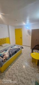 a bedroom with a bed and a yellow door at Couple Friendly Hotel - Sunset in Orchha