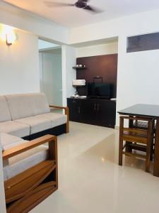 a living room with a couch and a table at VVP Rooms in Cochin +5 photos