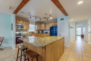 una cucina con armadi in legno e frigorifero blu di Sea Breeze 608 a St Pete Beach