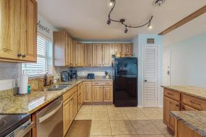 una cucina con armadi in legno e frigorifero nero di Sea Breeze 608 a St Pete Beach Altre 19 foto