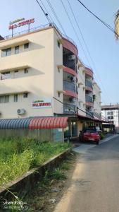 a building with a red car parked in front of it at VVP Rooms in Cochin