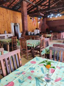 a restaurant with tables and chairs with flowers on them at Paineiras Pousada Rural in Ibiúna