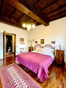 een slaapkamer met een groot bed met een roze sprei bij B&B Souvenirs d'Antan in Orvinio +61 foto's