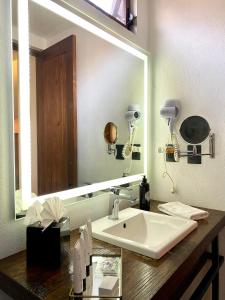 a bathroom with a sink and a large mirror at Hotel Boutique Casa Loreta in Querétaro