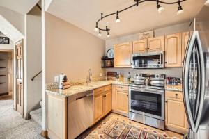 eine Küche mit Holzschränken und einem Kühlschrank in der Unterkunft 5959 Hidden River Lodge condo in Keystone + 20 Fotos