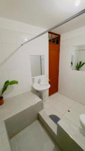 a white bathroom with a sink and a toilet at Castellares la Puebla Hostelería Departamento in Ayacucho