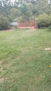 a field of grass with a red fence in the background at Villarrica in Valle Hermoso
