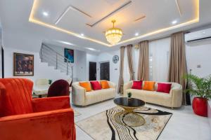 a living room with orange and red furniture and a chandelier at Shortlet spaces in Lagos