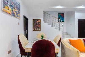 a dining room with a table and chairs and a staircase at Shortlet spaces in Lagos