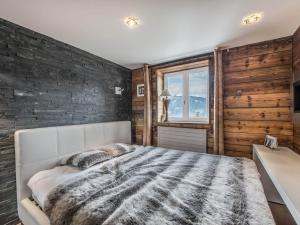 a bedroom with a large bed and a brick wall at Chalet Douillet à 200m des Pistes avec Cheminée, Balcon et Baignoire Balnéo - FR-1-562-17 in Courchevel