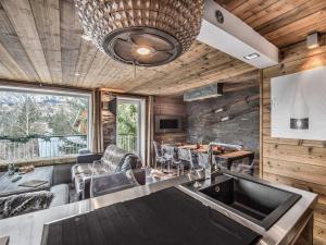 a kitchen and living room with a table and chairs at Chalet Douillet à 200m des Pistes avec Cheminée, Balcon et Baignoire Balnéo - FR-1-562-17 in Courchevel