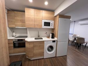 a kitchen with a washing machine and a microwave at Apartamento Manzana in Seville