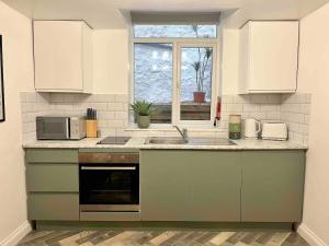 a kitchen with a sink and a microwave at Stylish Studio Apartment on Torquay Harbourside! in Torquay