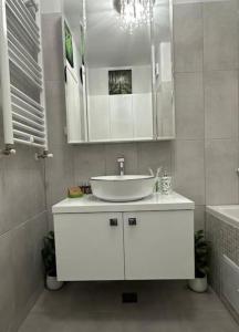a white bathroom with a sink and a mirror at Verdana apartament in Timişoara +16 photos