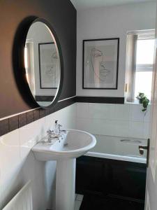 un bagno con un lavandino, una vasca e uno specchio di Large Modern home, 5 mins to town Centre a Enniskillen Altre 19 foto
