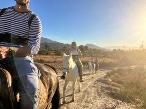 a group of people riding horses on a dirt road at Posada Rancho Malcaminos in Tabernas