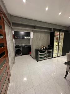 eine große Küche mit schwarzen Geräten und einem Fliesenboden in der Unterkunft Casa Carnaval 2025-São Benedito-CE in São Benedito