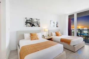 two beds in a room with a window at Amazing Balcony Near Beach in Hallandale Beach
