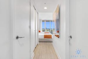 a corridor of a bedroom with a bed and a window at Amazing Balcony Near Beach in Hallandale Beach